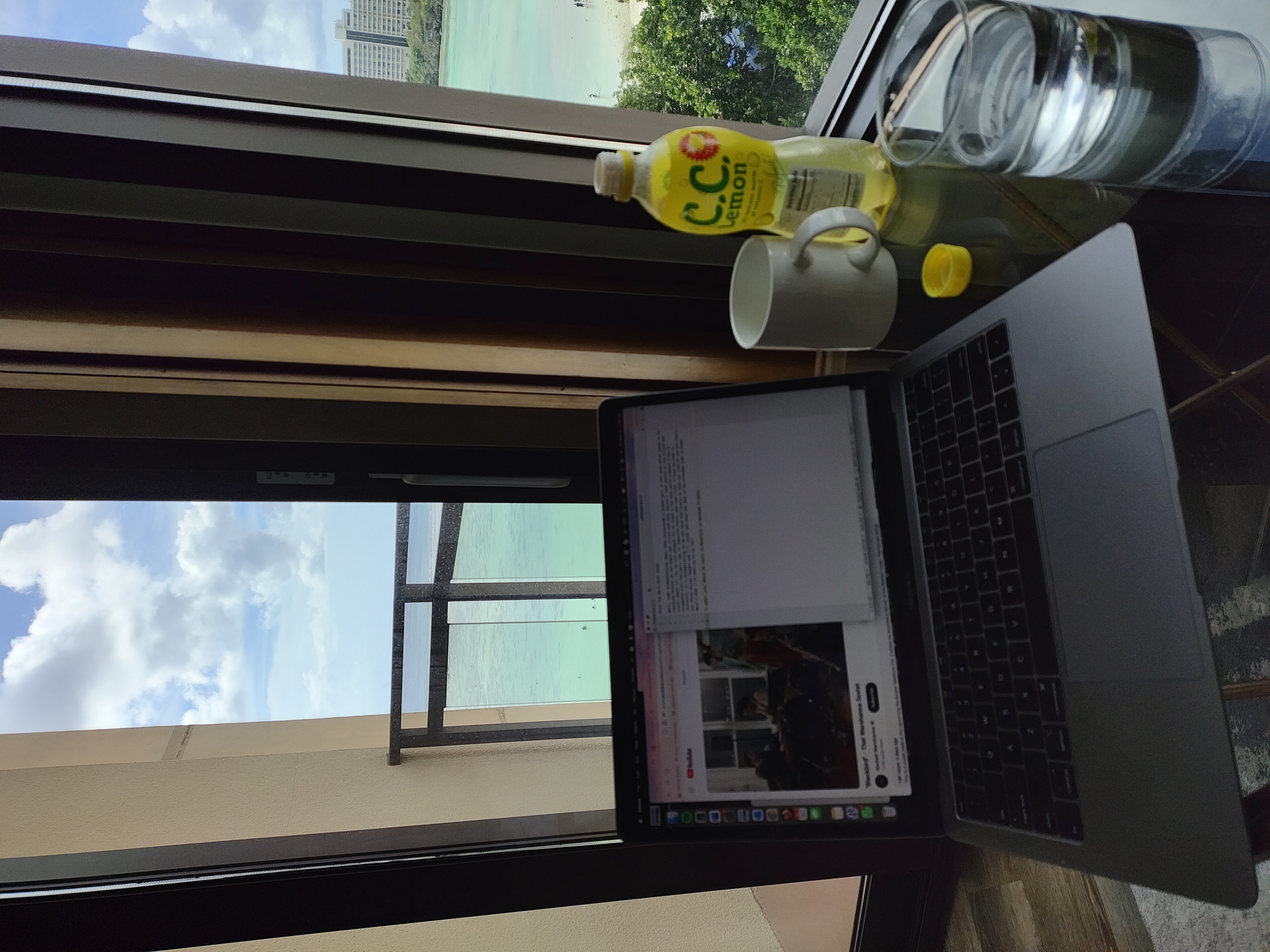 a small glass table facing windows with an ocean view